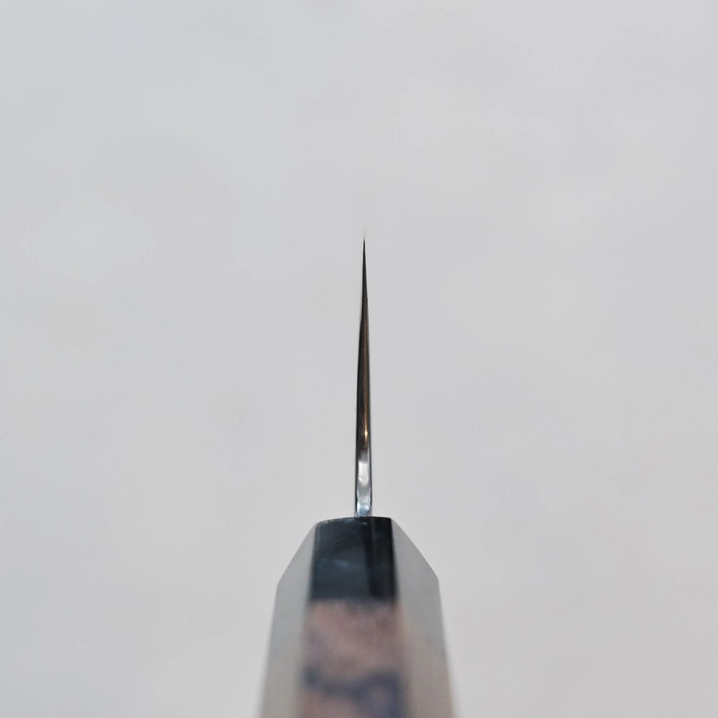 Close-up of a kiritsuke gyuto blade showing its damascus steel pattern and 270mm length.