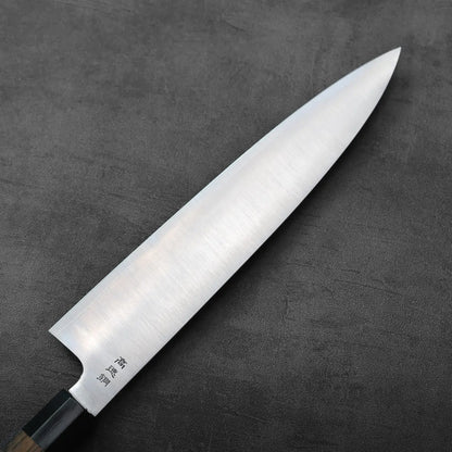 Gyuto with a wooden handle and 270mm blade, resting alone.