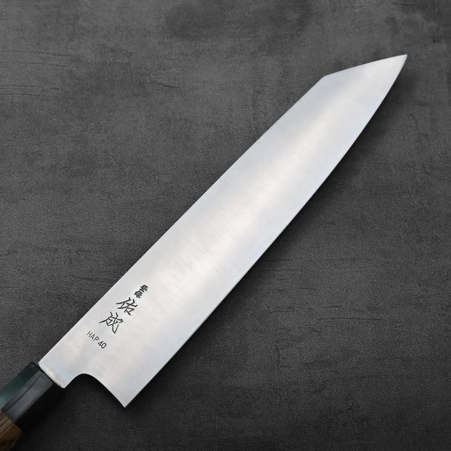Kiritsuke gyuto with kanji engraved on the blade. The handle and blade are clearly visible in the image.