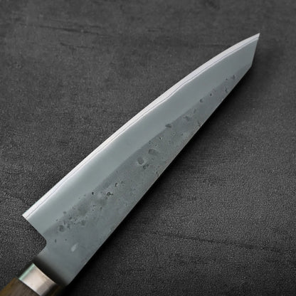 Close-up of honesuki with wooden handle, highlighting knife details and texture in a focused shot.