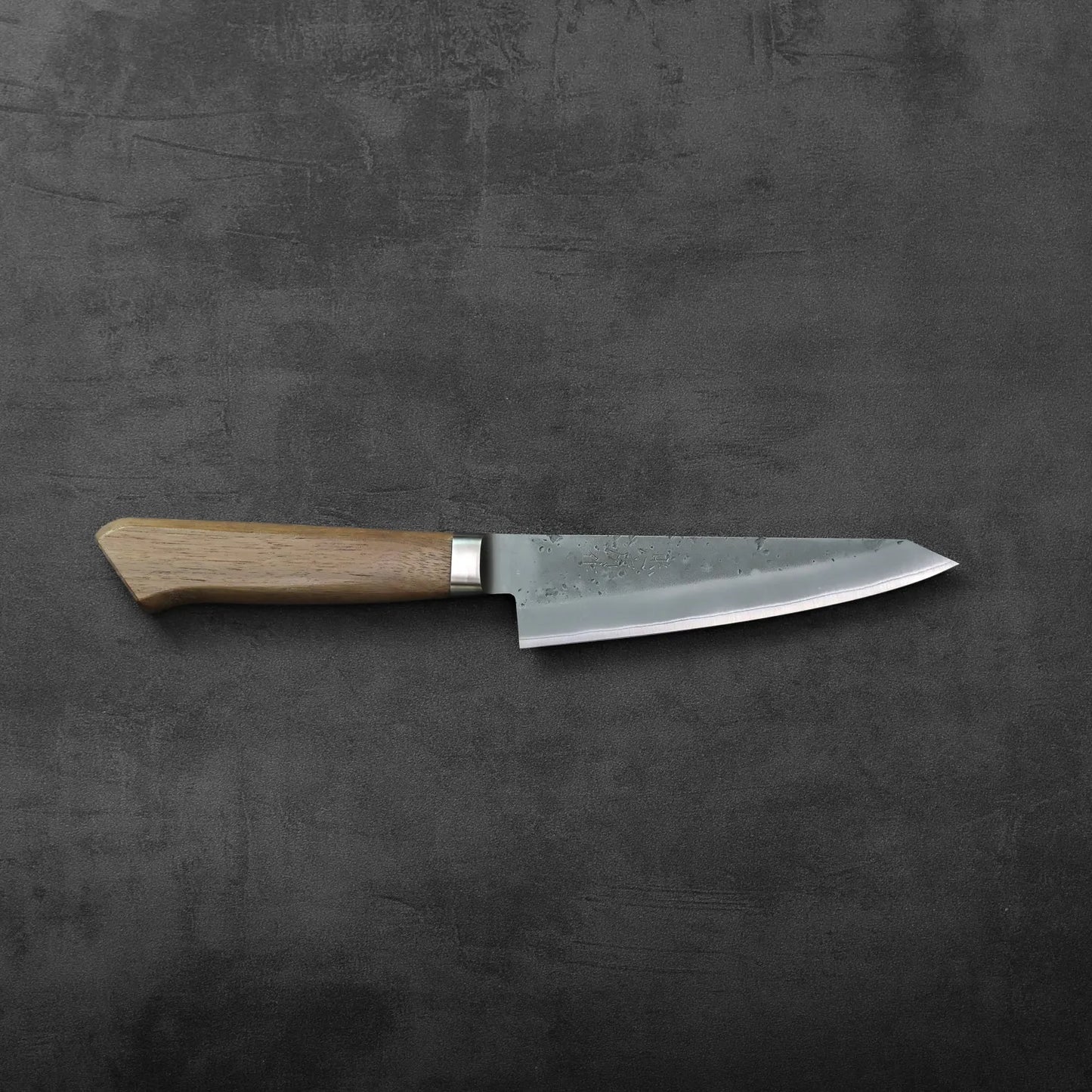 Honesuki with a wooden handle, blade visible and angled to show subtle texture and steel finish.