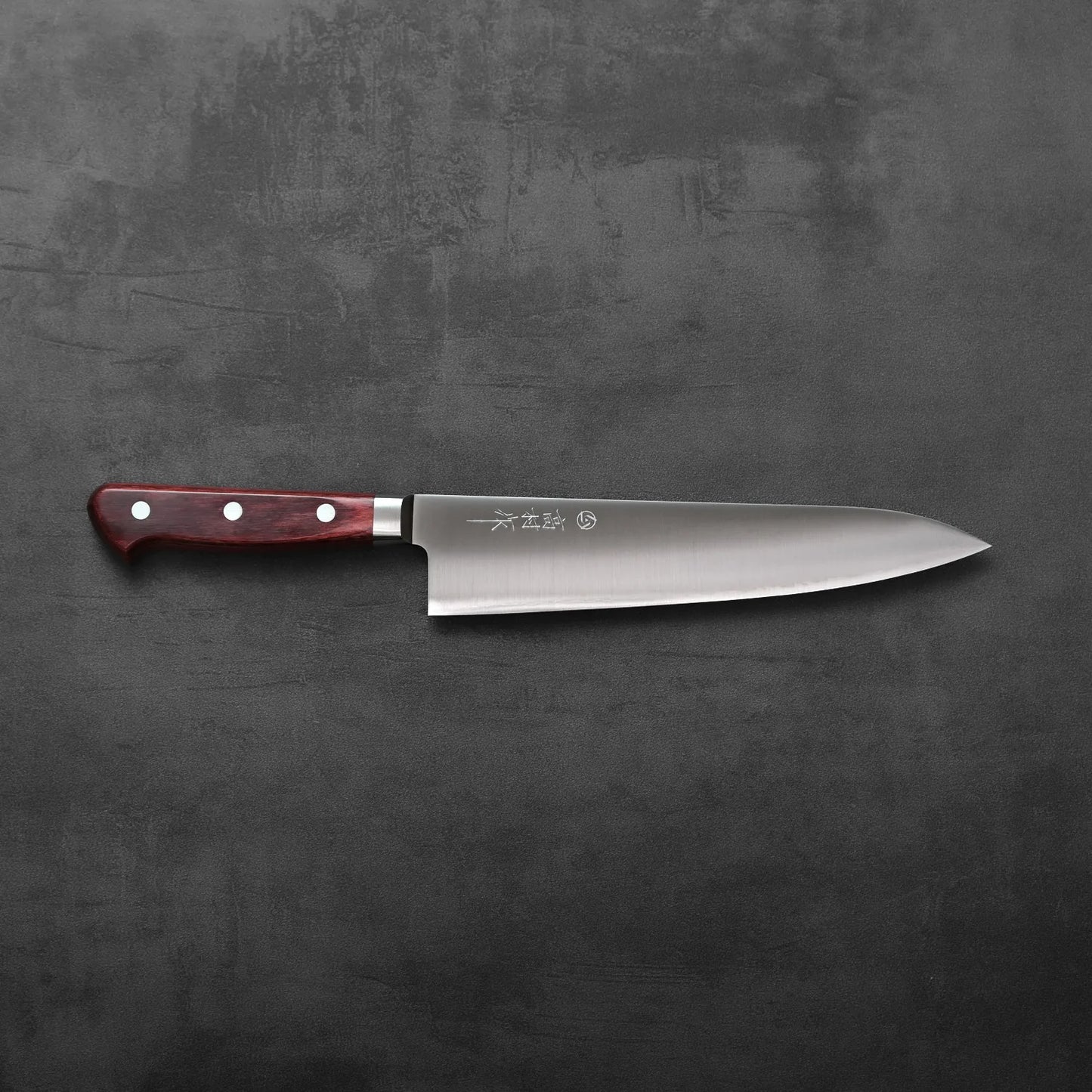 Gyuto with a red handle and silver rivets, showing clean lines and detailed handle construction.