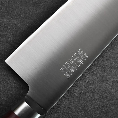 Close-up of a gyuto blade with engravings in focus, showing metal texture and detailed markings.
