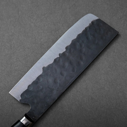 Nakiri with a dark, textured blade. The knife’s design is highlighted in close-up detail.