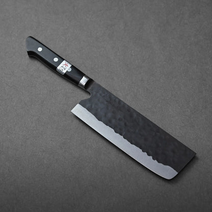 Nakiri with a hammered blade, shown resting and highlighting its unique textured metal and classic profile.