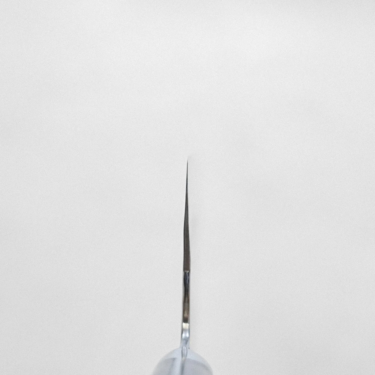 A syringe needle close-up, echoing the refined form of a bunka with tall, distinctive proportions.