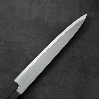 Sujihiki knife with a single edge, positioned to show the blade and handle details.