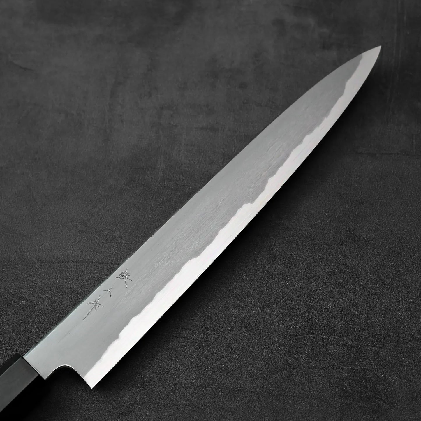 A sujihiki knife with a kasumi finish and 240mm blade is displayed with distinct visual details.