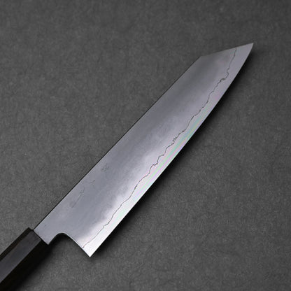 A detailed close-up of a kiritsuke gyuto knife blade, highlighting its ginsan stainless steel construction and kasumi finish. The image shows the subtle, cloud-like texture on the upper portion of the blade transitioning to a reflective, polished cutting edge. Light subtly catches the different finishes along the blade's length.