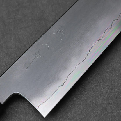
A close-up view of the ginsan stainless steel blade of a kiritsuke gyuto knife, highlighting the visible kanji engraving on the upper portion and the distinct wavy line of the kasumi finish. The polished edge is visible at the bottom of the frame.