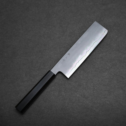 A Tetsujin kasumi ginsan nakiri 180mm with a straight edge and a dark handle rests on a dark textured surface. This nakiri knife features subtle blade patterning and engraved markings near the handle.