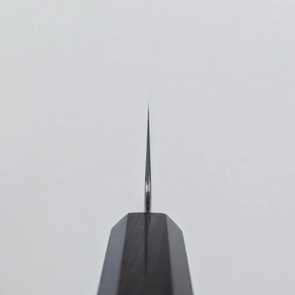 Choil shot of a knife blade displaying a thin, straight edge, positioned vertically against a plain white background for detailed examination.