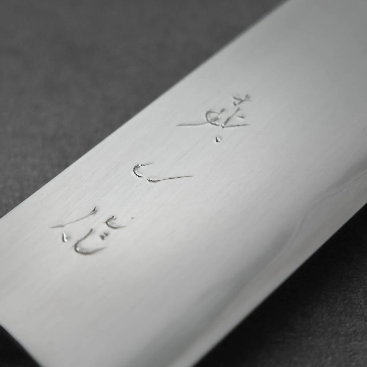 Gyuto with Japanese characters engraved on the flat of the steel blade.