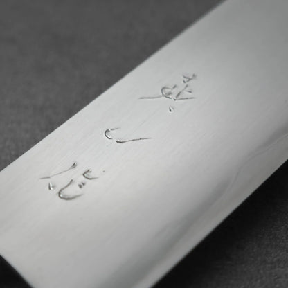 Gyuto with Japanese characters engraved on the flat of the steel blade.