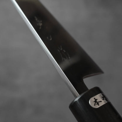 Honesuki with a dark, engraved blade and a black cylindrical handle.