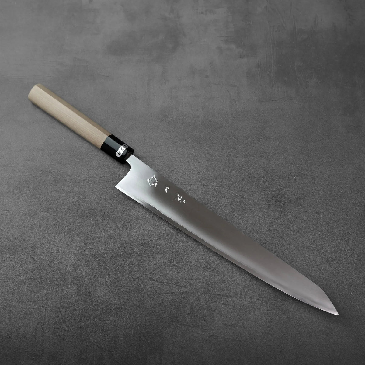 Sujihiki with a long blade, light wooden handle, and a black ferrule.