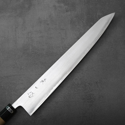 Sujihiki with a long, thin, pointed blade and a wooden handle with a black ferrule.