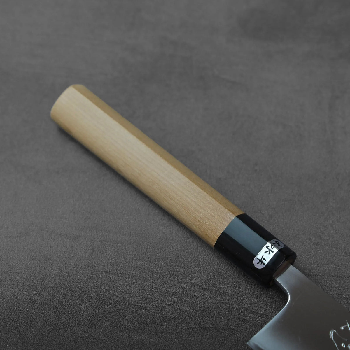 Sujihiki with an octagonal wooden handle and a black ferrule featuring a white sticker.
