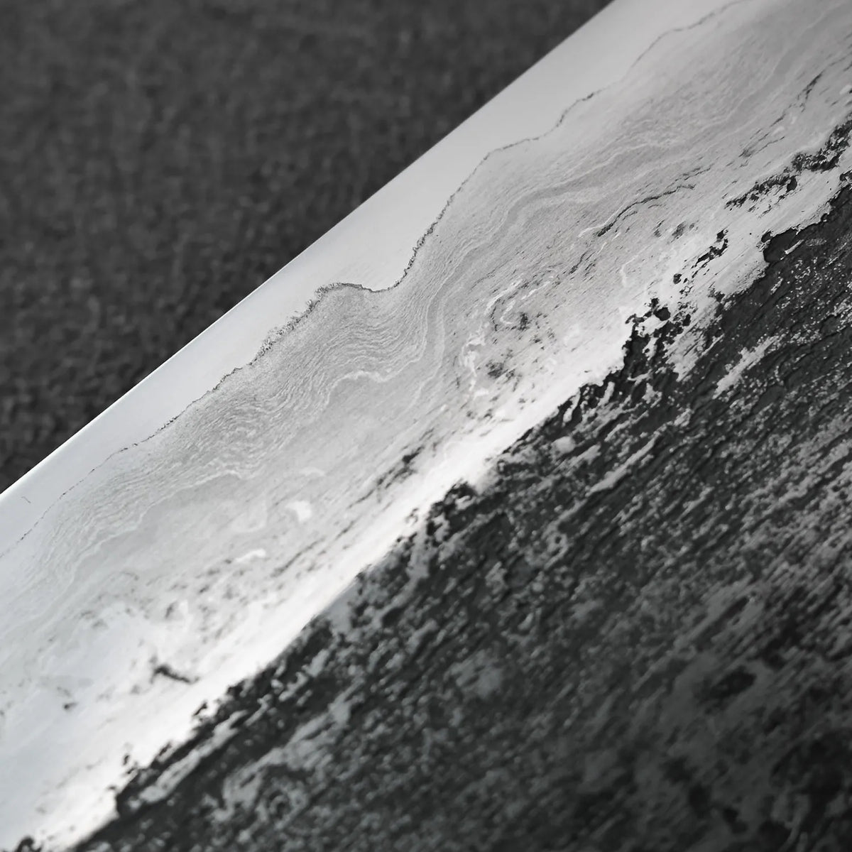 Gyuto with extra tall 240x58mm layered blade and wrought iron cladding, shown in close-up detail.