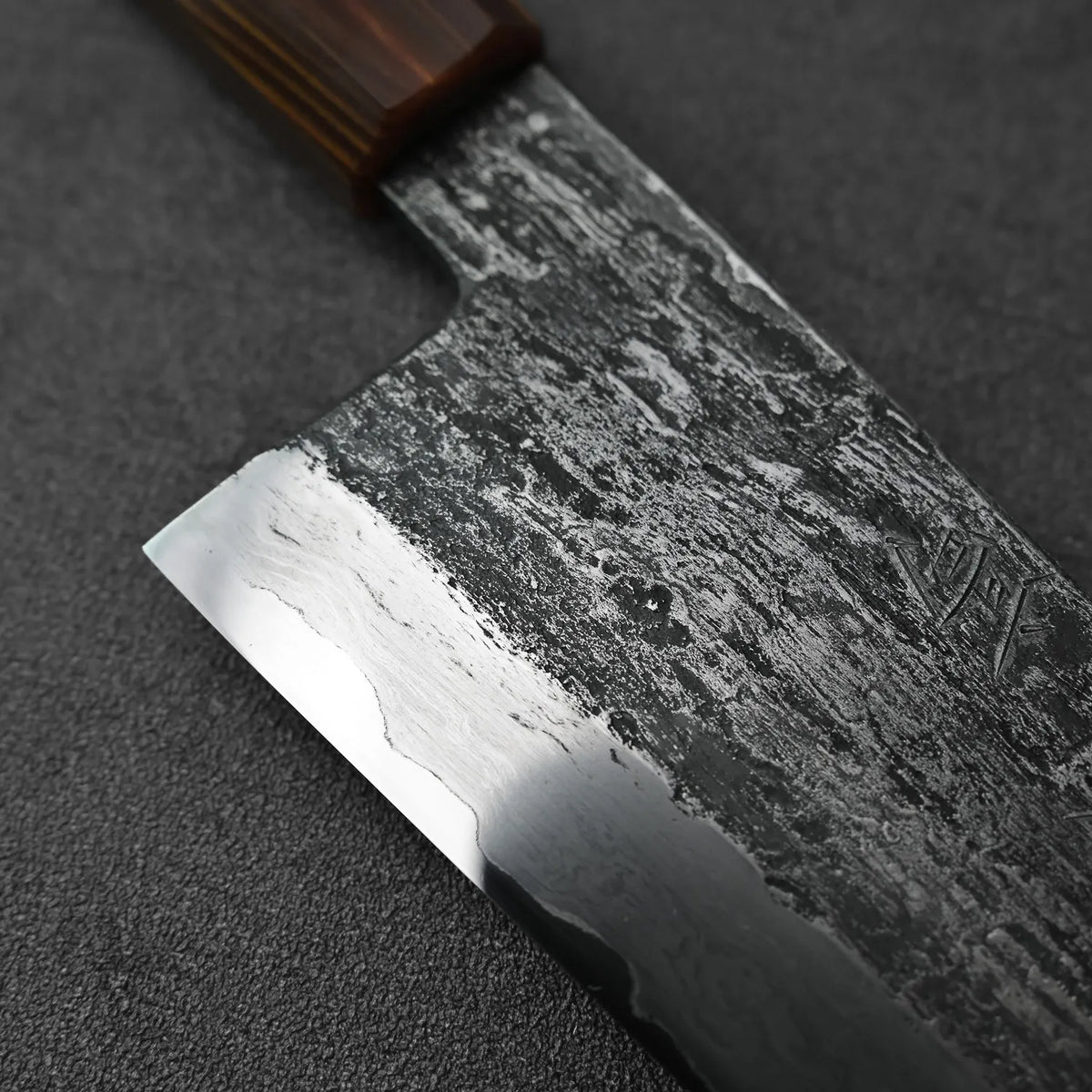 Close-up of a gyuto with an extra tall blade, showing details of the handle and blade profile.