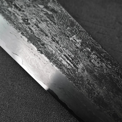 Gyuto blade shown in close-up, featuring extra tall aogami#1 steel with wrought iron cladding.