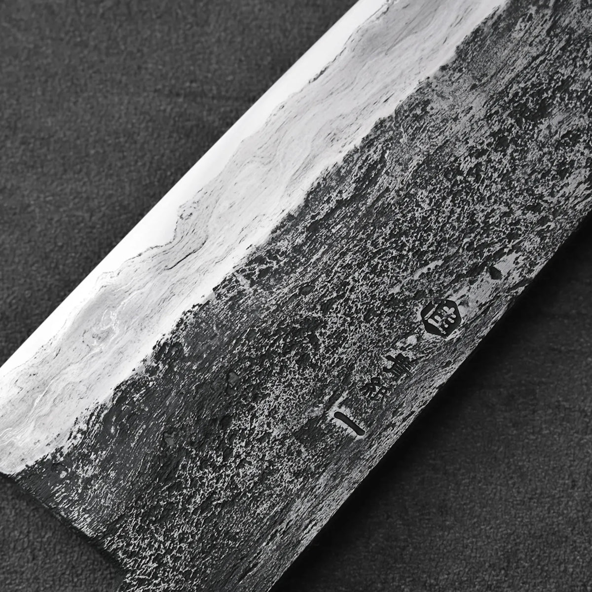 Close-up of a gyuto with Damascus patterns, showcasing intricate layered details on the blade.
