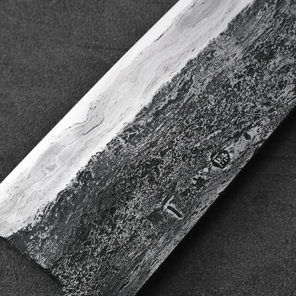 Close-up of a gyuto with Damascus patterns, showcasing intricate layered details on the blade.