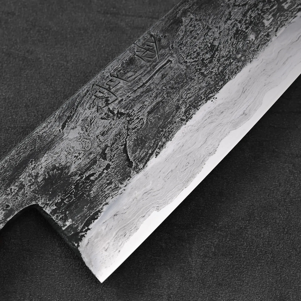 Gyuto with wrought iron cladding, featuring a tall 240x55mm blade. Close-up captures texture and finish.