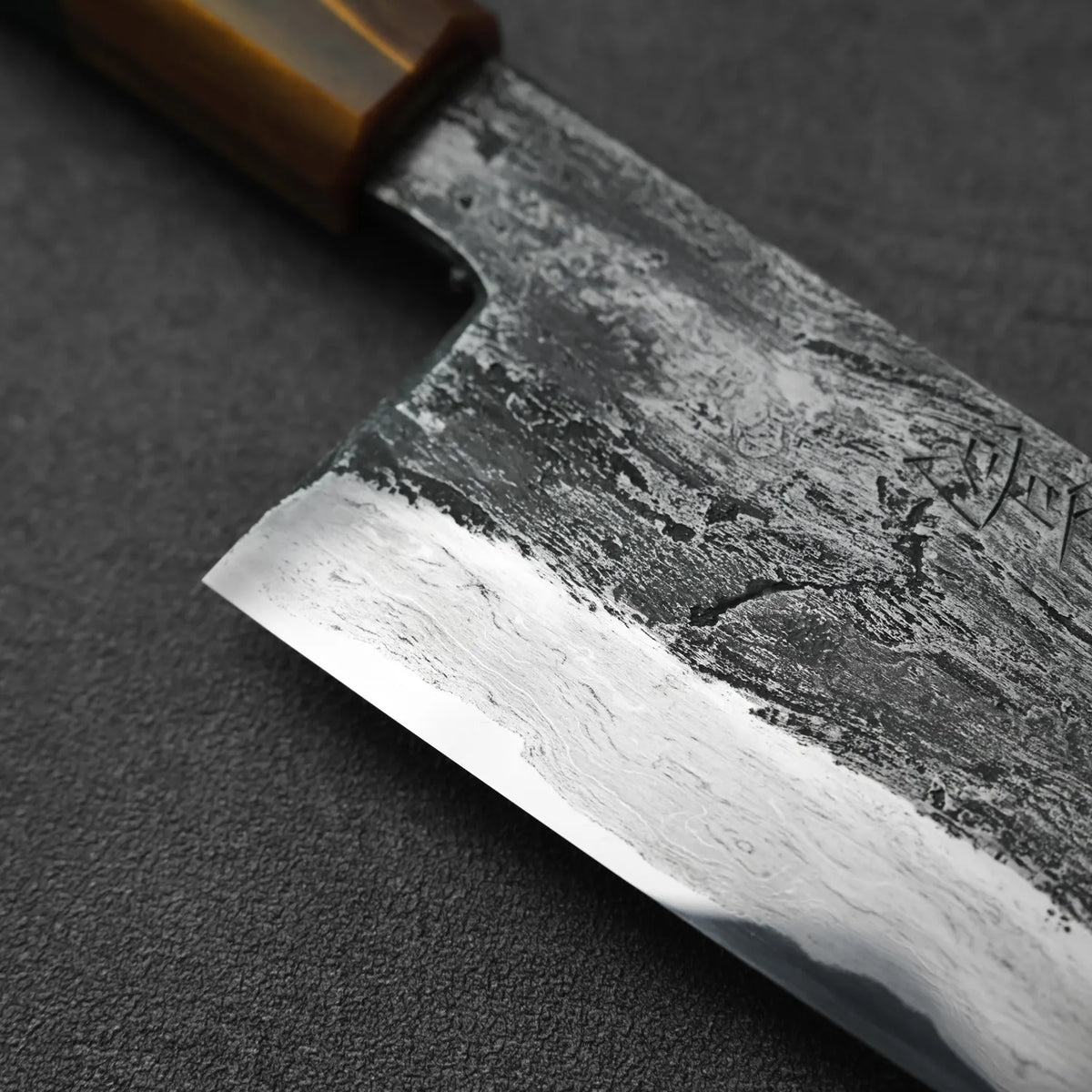 Close-up of a gyuto with a wooden handle, showing its tall blade profile and detailing.