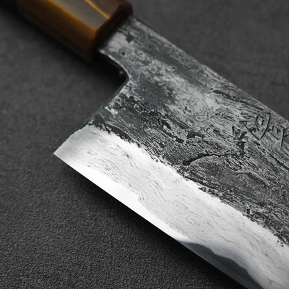 Close-up of a gyuto with a wooden handle, showing its tall blade profile and detailing.