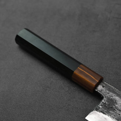 Gyuto with a dark hex handle, shown in close-up to display its tall 240x55mm blade.