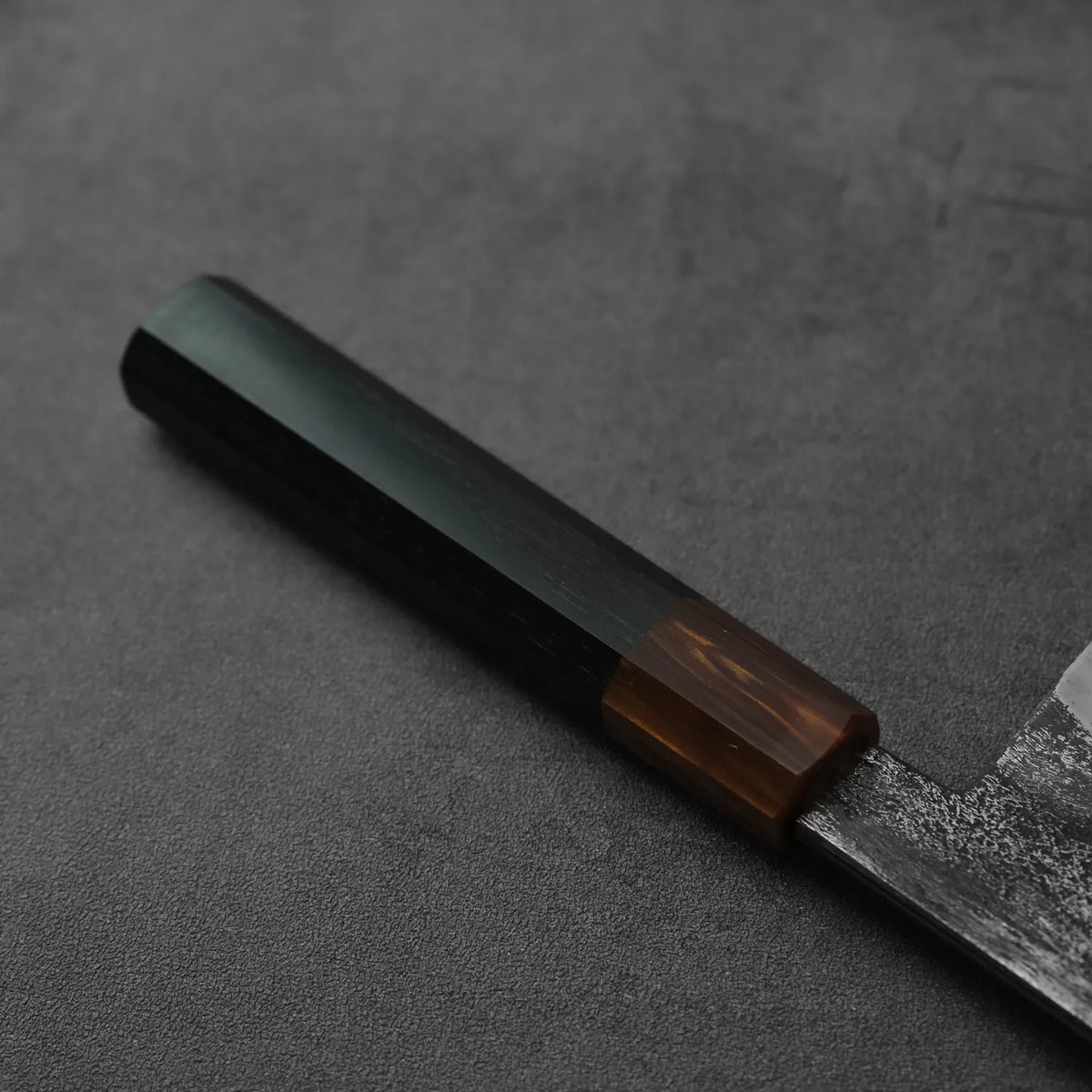 Close-up of a gyuto with a dark wood handle, highlighting its tall blade proportions.