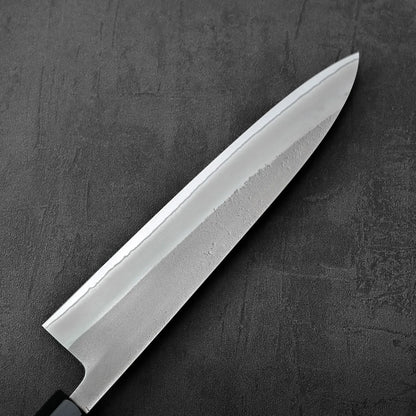 Close-up of a gyuto featuring visible nashiji finish and shirogami#2 steel, focus on blade detail.