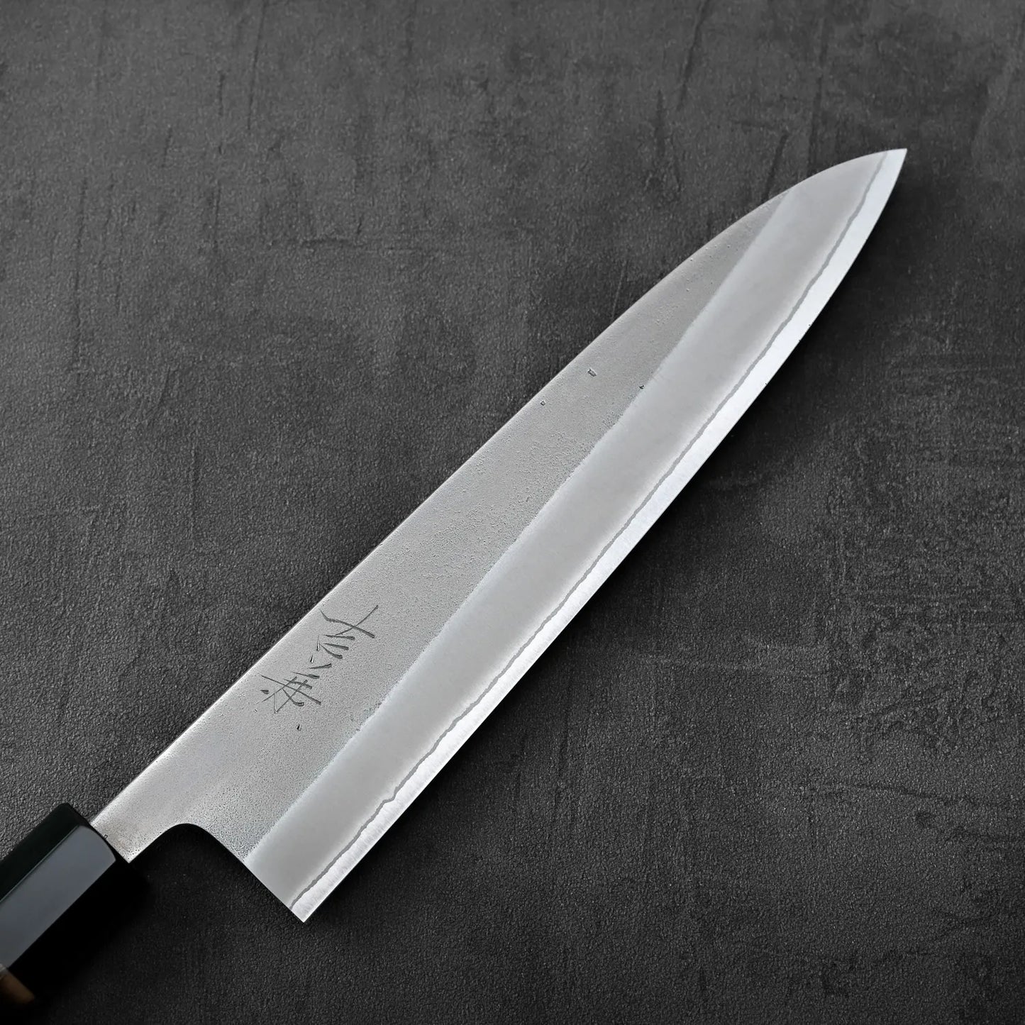 A gyuto with a burnt chestnut handle featuring nashiji finish and shirogami#2 steel.