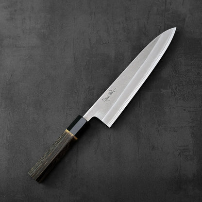 A Yoshikane nashiji shirogami#2 gyuto 210mm with a burnt chestnut handle is displayed, highlighting its shape and wood grain handle.