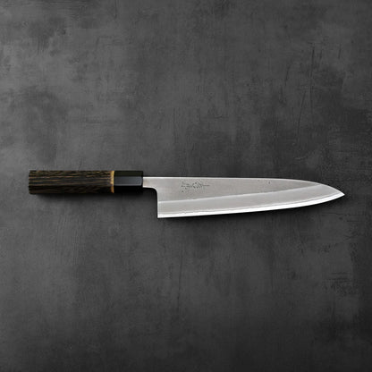 A gyuto with a burnt chestnut handle, showing a nashiji finish on the blade.