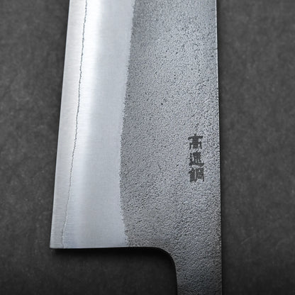 Close-up view of a Japanese chef's knife blade, featuring a textured pattern and engraved Kanji characters, set against a dark background.