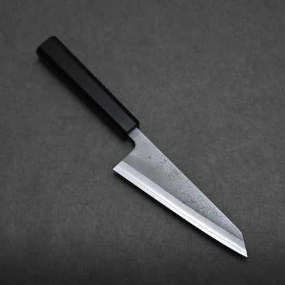 A Japanese honesuki knife with a straight-edged blade and a black rectangular handle, resting on a dark gray textured surface.