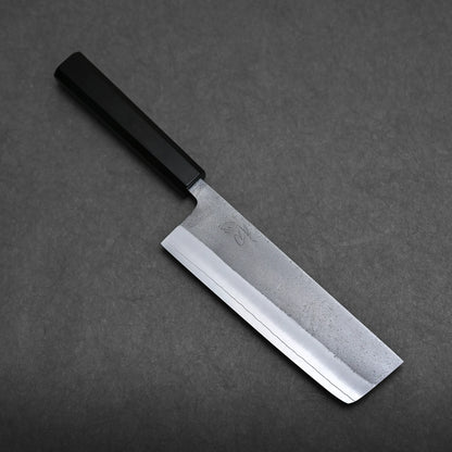 A Japanese-style kitchen knife with a black handle and a rectangular, straight-edged, steel blade is placed on a dark grey surface.
