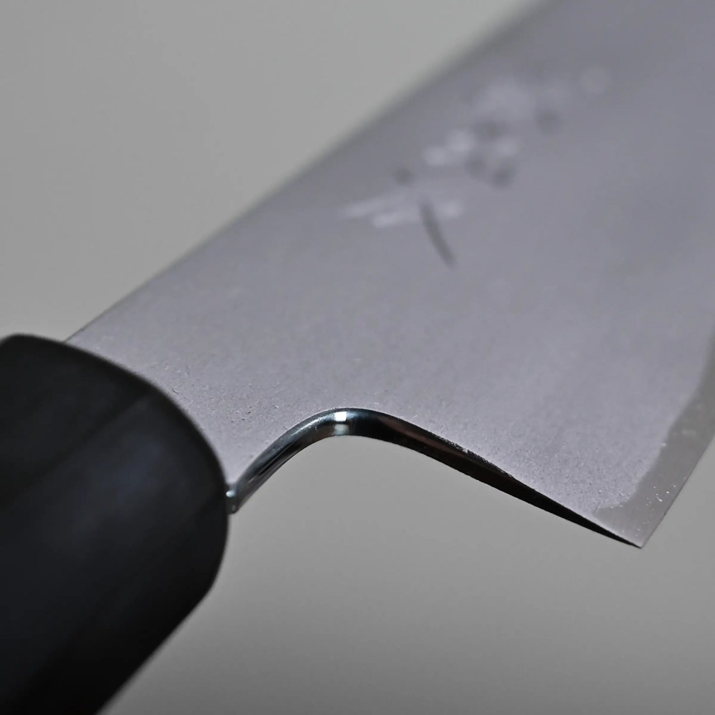 Close-up view of the choil finish on a Japanese petty knife.