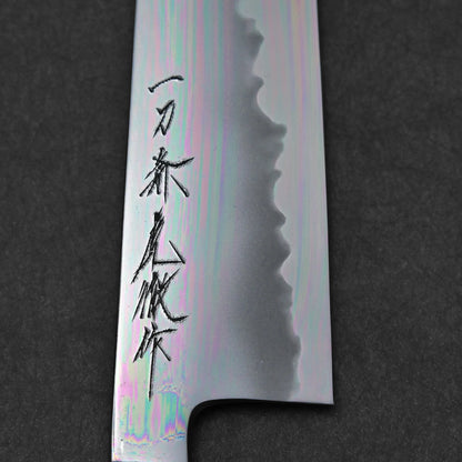 A close-up of the aogami#1 blade, showing wavy cladding line and kanji, highlights its expert craftsmanship against a dark background.