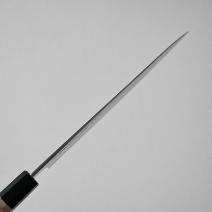 A close-up of kitchen knife shows its spine against a plain light gray background, emphasizing the narrow profile from a side view.