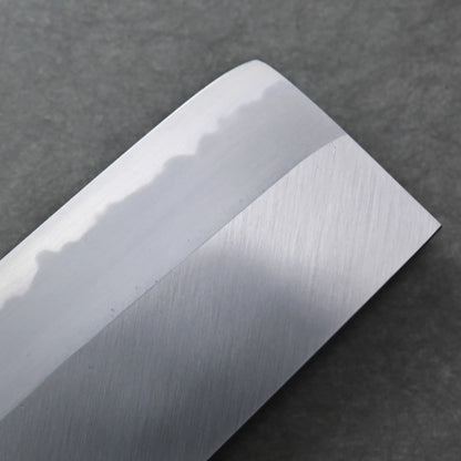Close-up of a polished Tanaka AS nakiri blade with a visible wavy hamon line, set against a dark textured background.