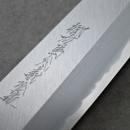 Close-up of a polished knife blade featuring Japanese kanji characters engraved on the surface, displayed against a dark, textured background for an authentic aesthetic.