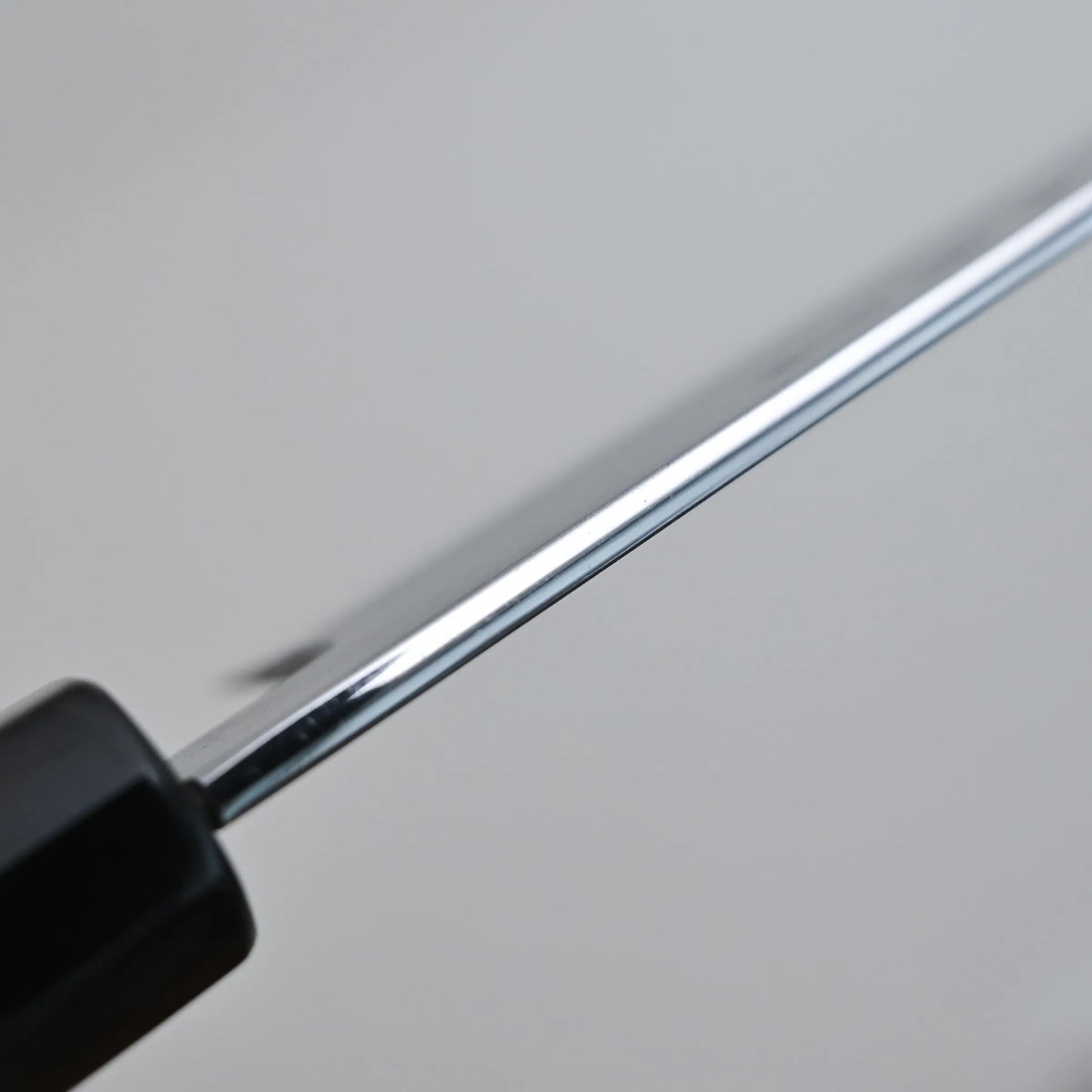 Close-up photo of the spine finish, positioned diagonally against a plain, light-colored background 