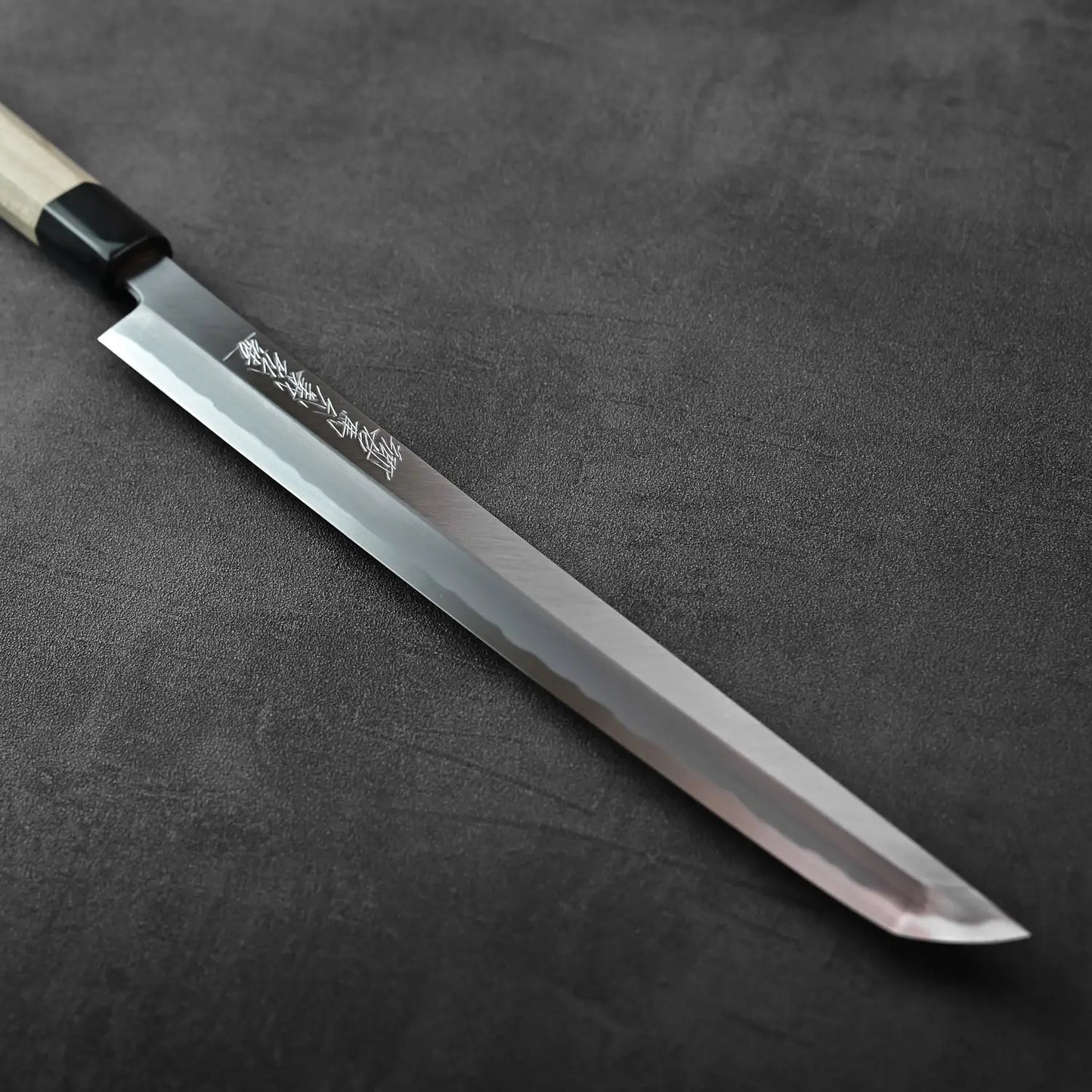 Sakimaru sujihiki with a wooden handle and saya, showing its length and shape, handle detail visible.