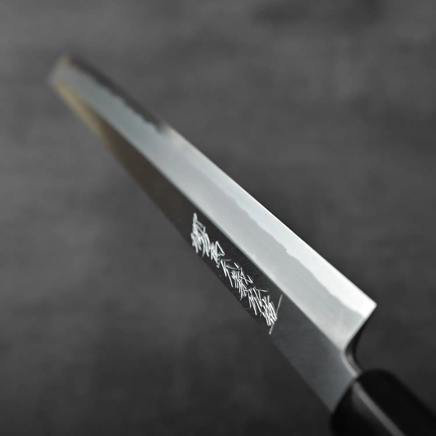 Close-up of a sakimaru sujihiki 300mm knife with saya, highlighting its distinct blade and handle design.