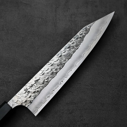 Kiritsuke gyuto with a hammered blade, shown in close-up to highlight its detailed texture.