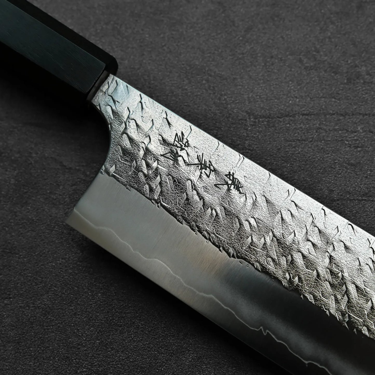 Close-up of a nakiri featuring blade engraving, showcasing details and steel texture.