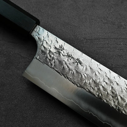 Close-up of a nakiri featuring blade engraving, showcasing details and steel texture.
